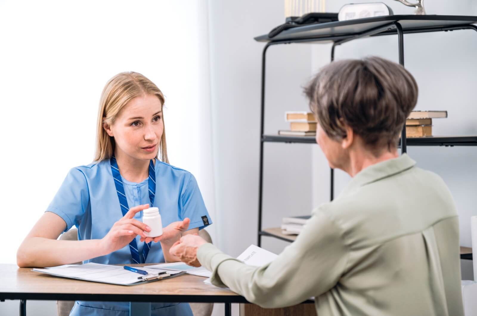 A healthcare professional recommending a multivitamin to an older adult.