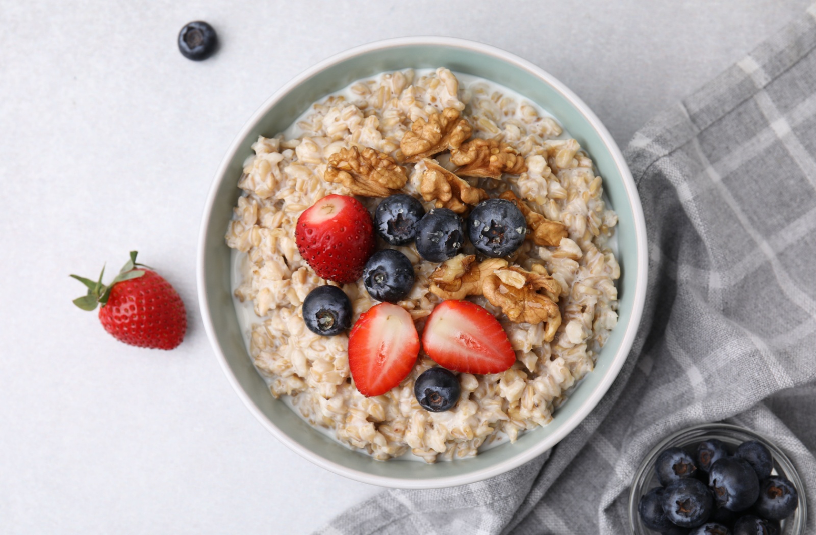 A top-down image of a bowl of oatmeal with berries and nuts.