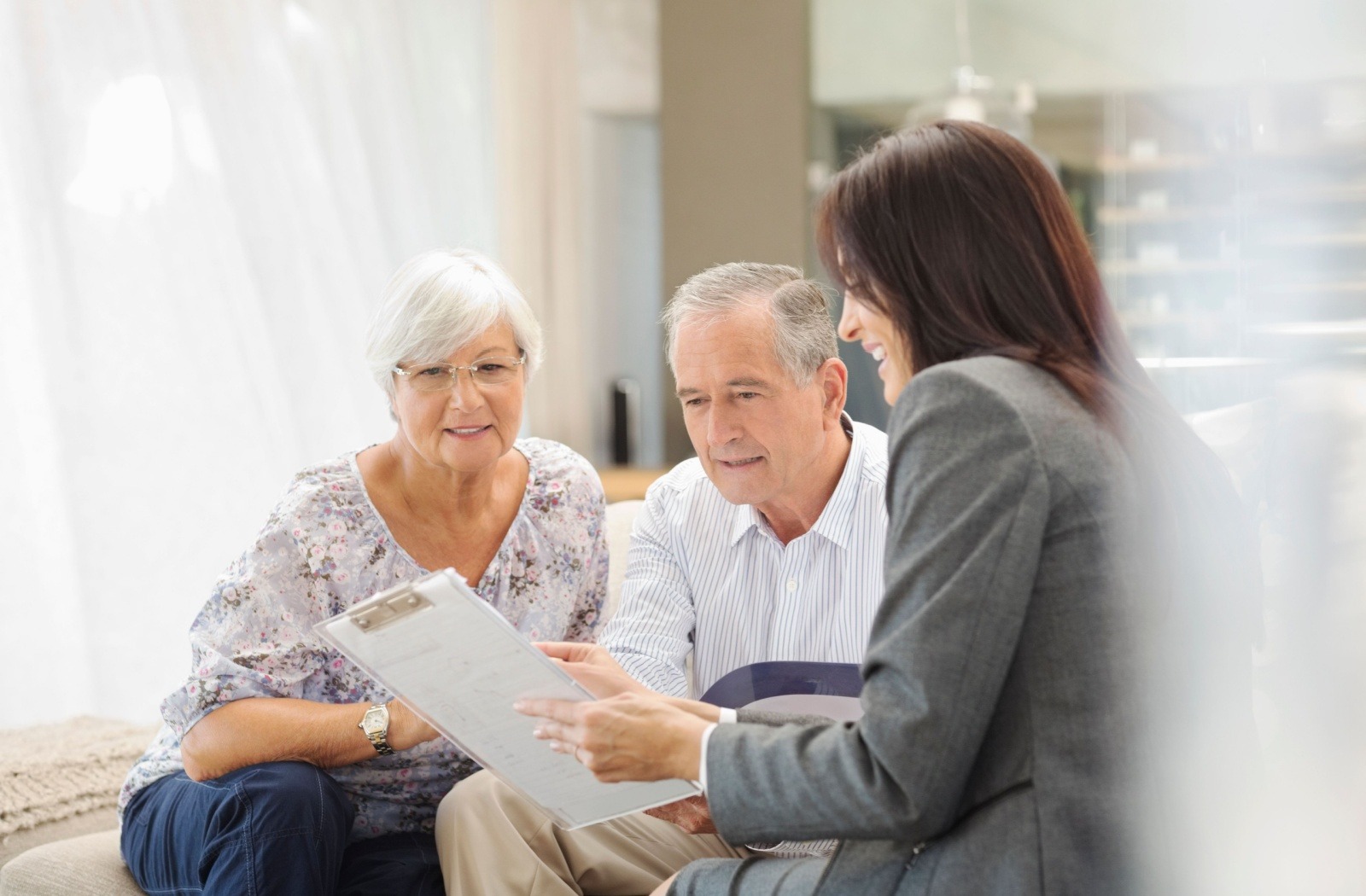 A senior couple works with a senior living community employee.